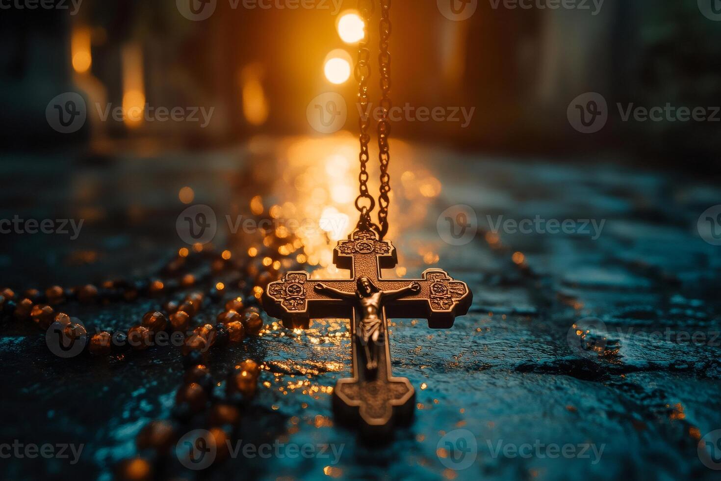 Crucifix and rosary lying on stone surface with warm back light photo
