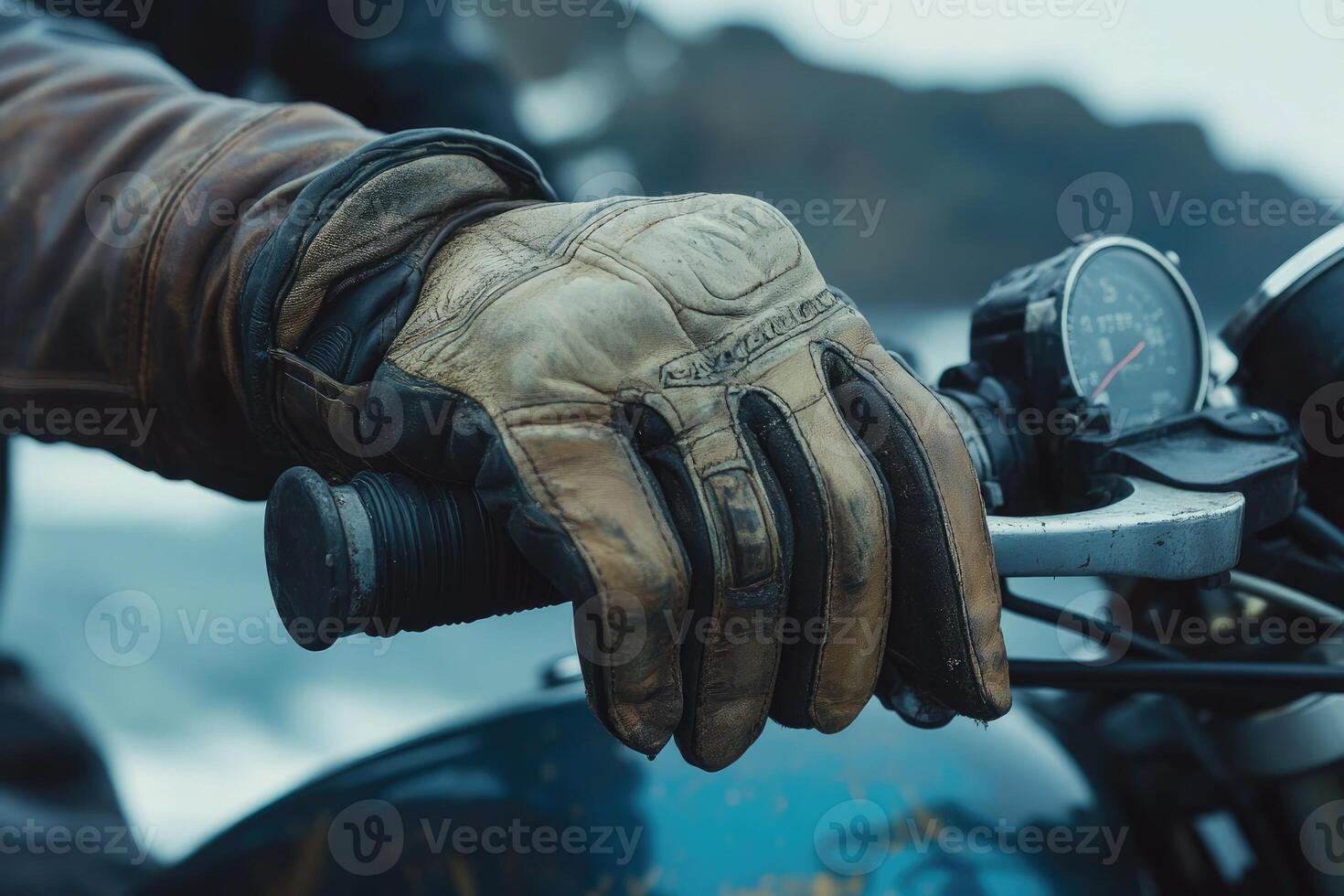 Close up of biker's hand gripping throttle control of classic motorcycle photo