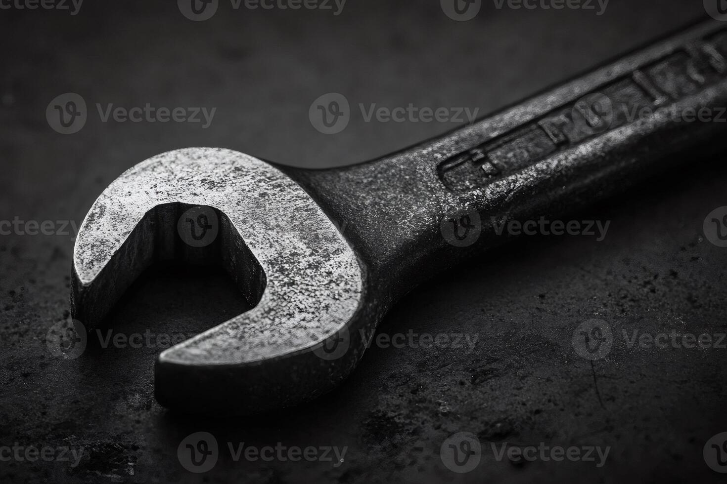 Close up of a rustic metal wrench on dark surface photo