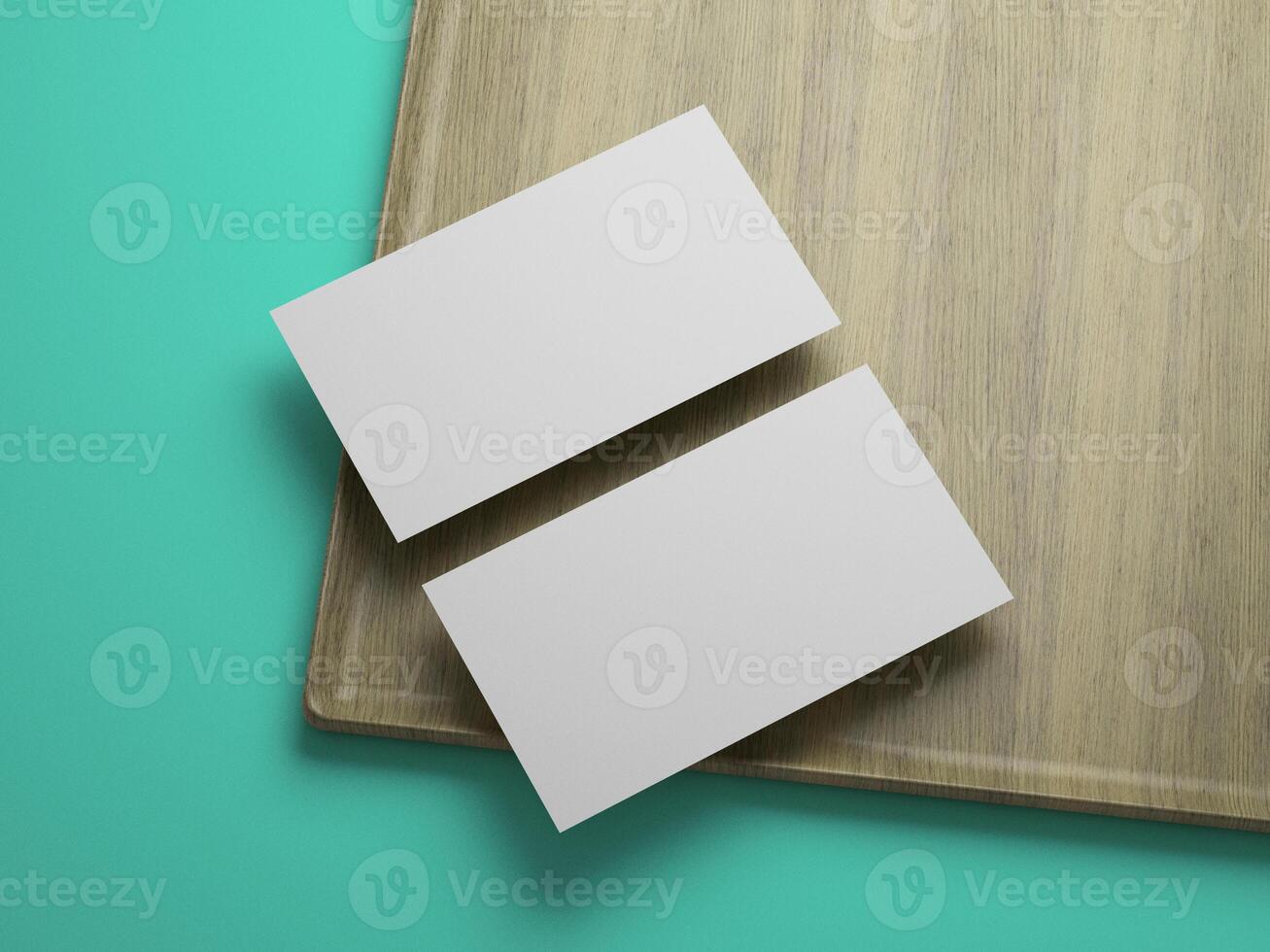 Blank business cards with subtle shadow on cornered tray and teal background. photo