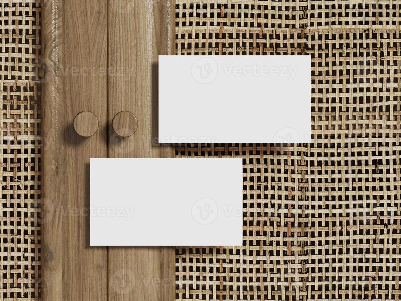 Blank business card mockup displayed on a rattan textured background with a sleek wooden border. photo