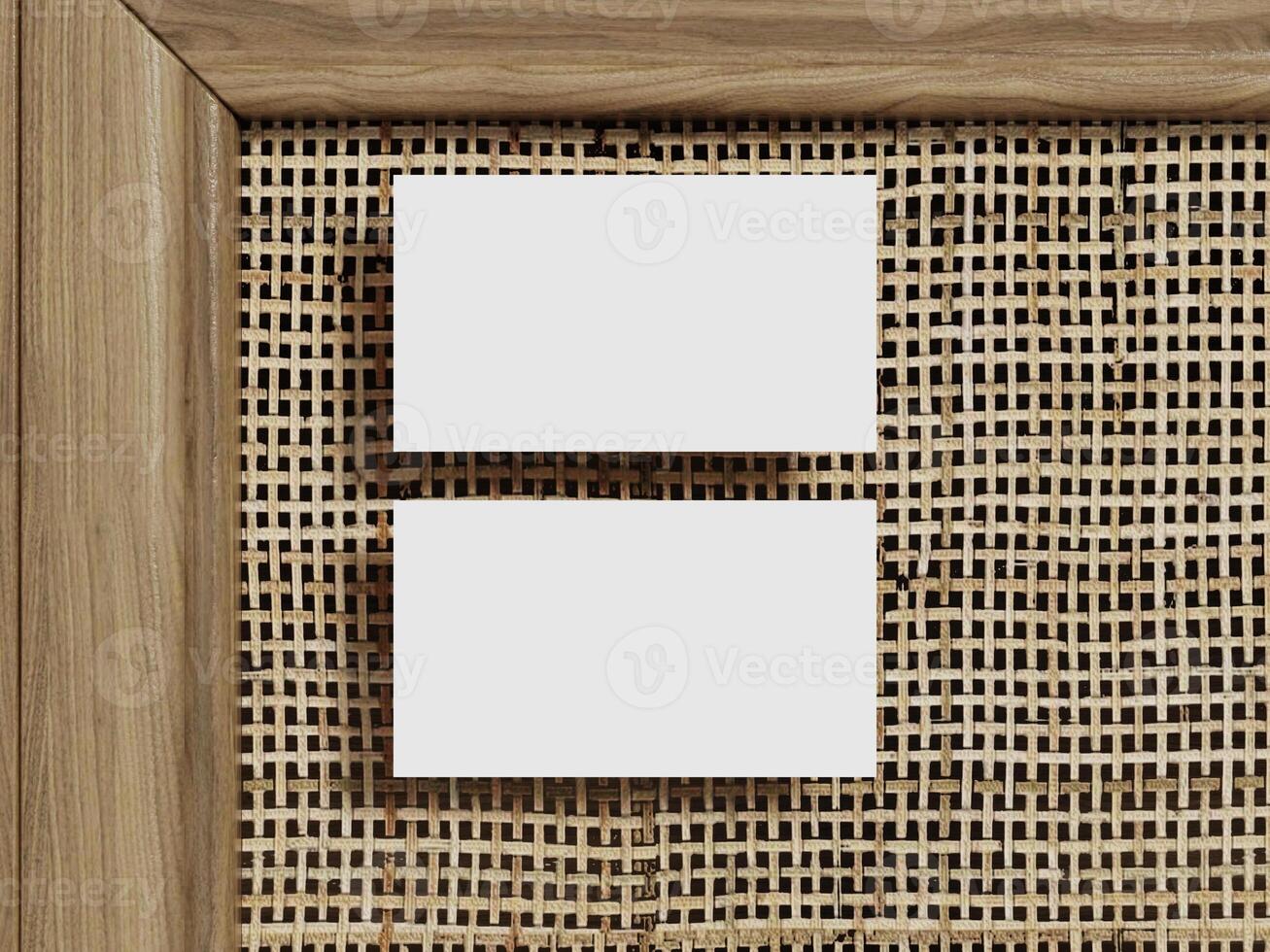 Business card mockup featuring two blank cards positioned vertically on a textured rattan surface, surrounded by warm wooden framing. photo