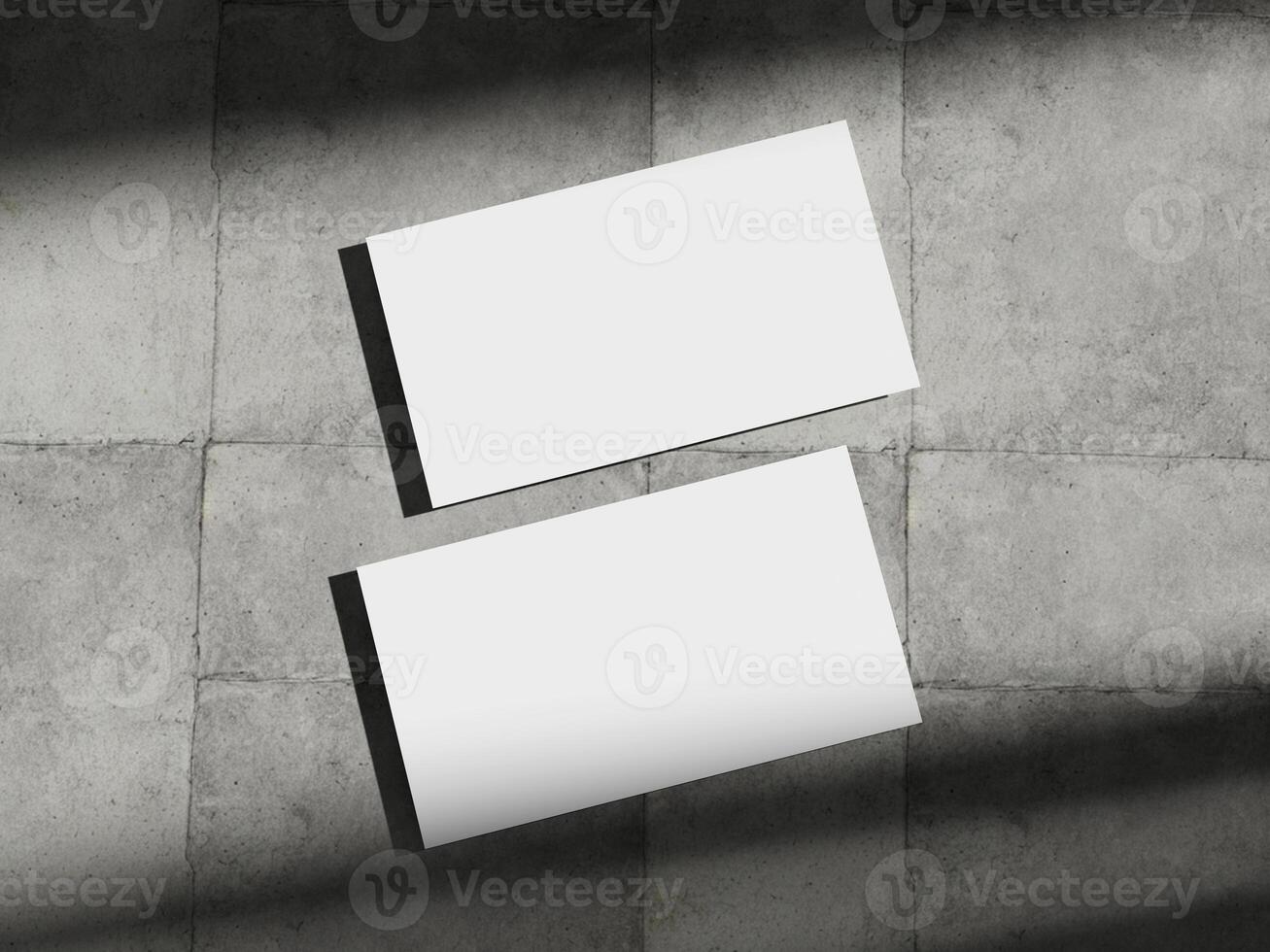Business card mockup placed on a concrete floor, highlighting the simplicity and elegance of corporate design. photo
