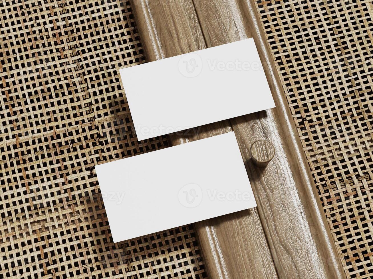 Business card mockup showcasing two blank cards with wooden framing, placed on a rattan background. photo