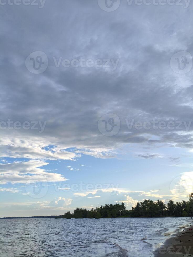 A beach with a body of water and a sky photo