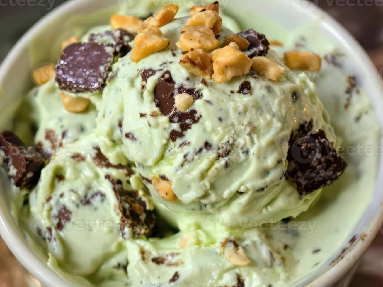 A bowl of green ice cream with nuts on top photo