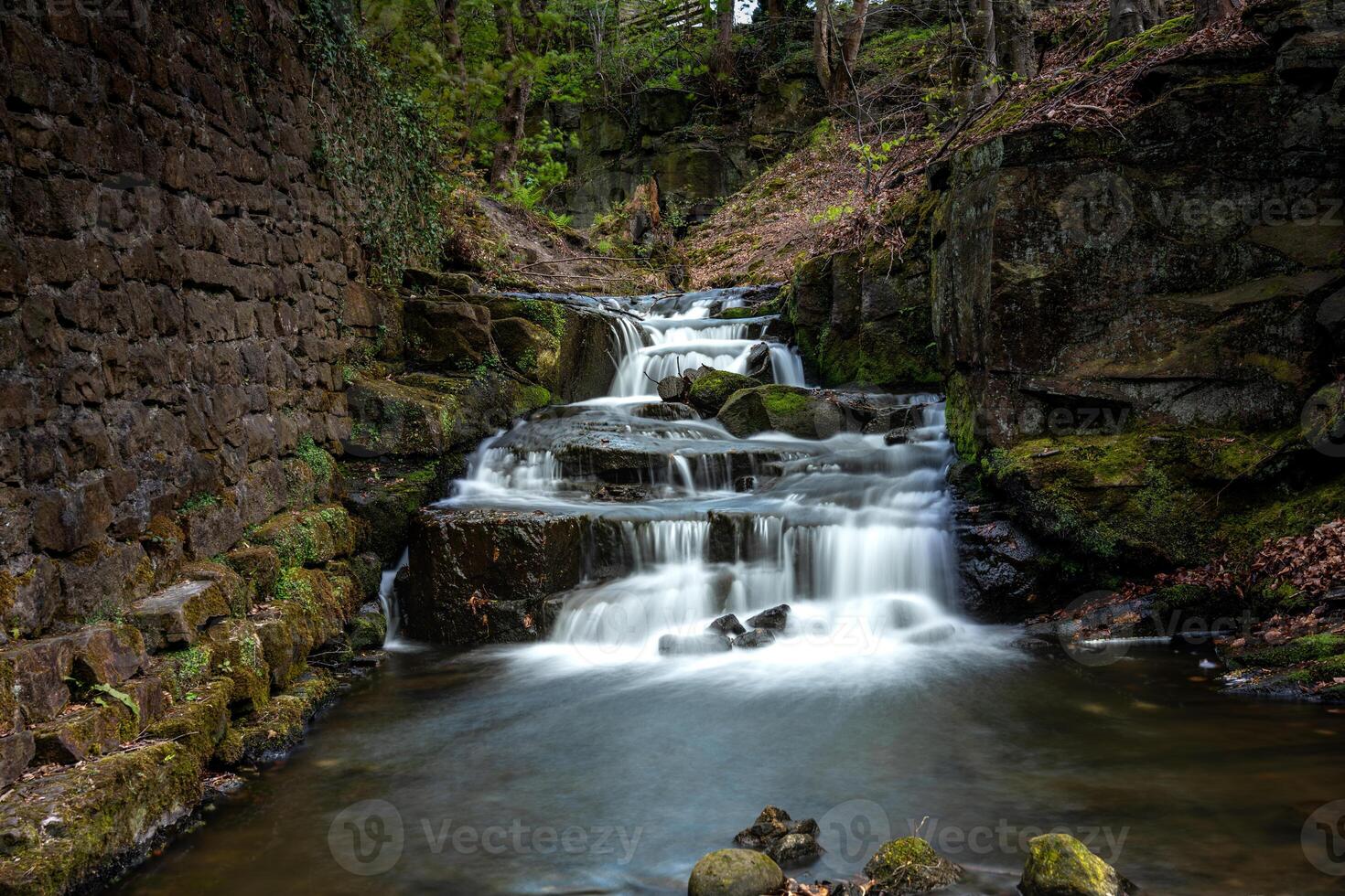 Waterfall cascading down rocks in a peaceful forest setting photo