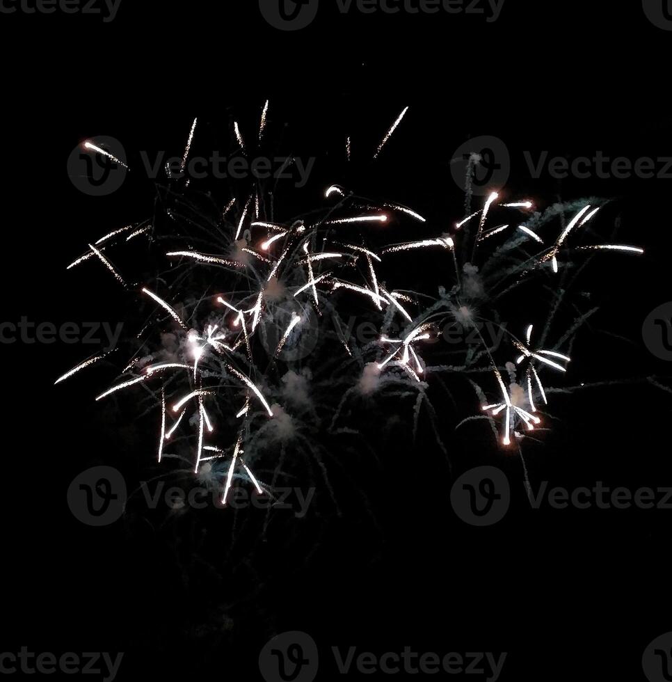 Stunning firework display against a black night sky. Captivating bursts of light and trails create a dramatic and festive atmosphere, perfect for celebrations, holidays, and event promotion. photo