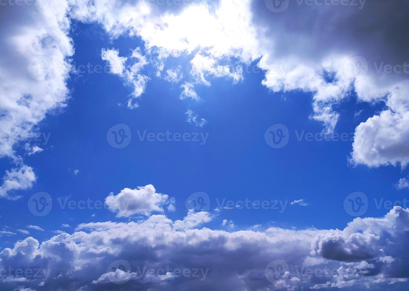 Bright blue sky framed by fluffy white and dark clouds. Inspiring, peaceful, and perfect for adding depth to design projects, websites, or marketing campaigns. photo