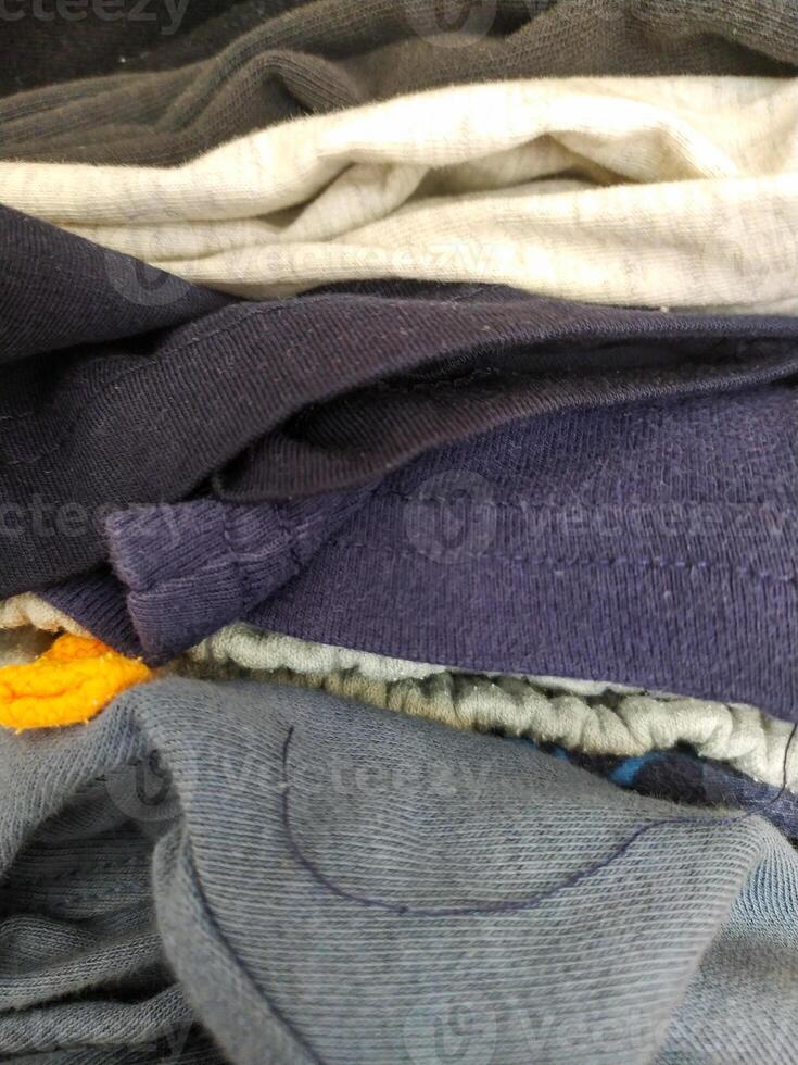 Abstract closeup of folded casual garments. Textiles in varying shades, perfect for backgrounds or illustrating texture, fabric or laundry concepts. photo