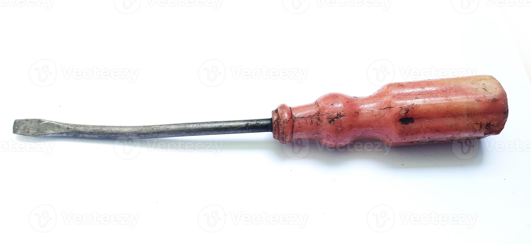 Vintage screwdriver with a worn, reddish handle and a slightly curved shaft, isolated on a white background. photo