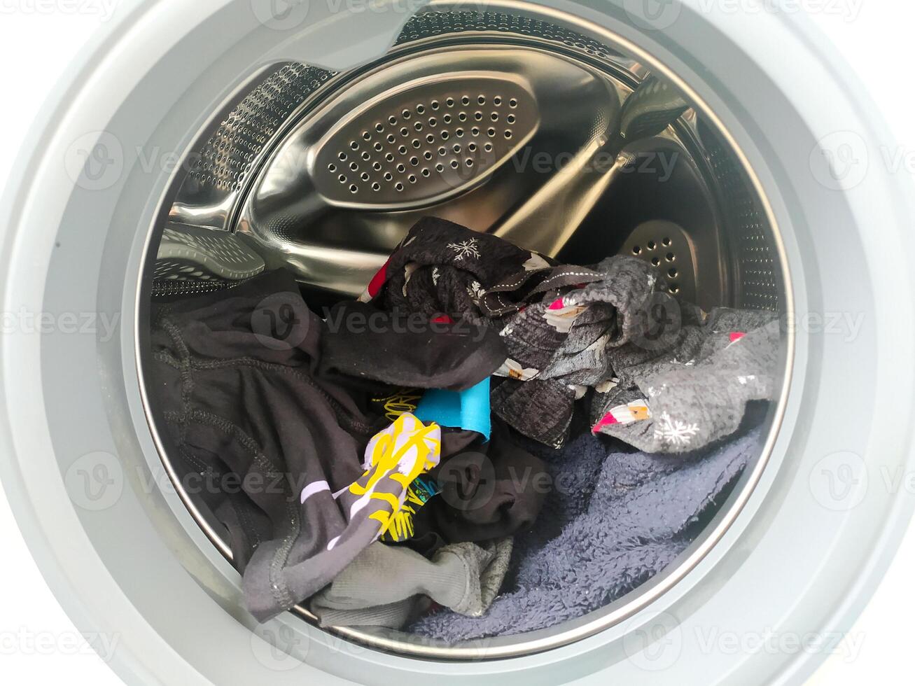 Laundry day a full washing machine ready to spin. Closeup, direct view, laundry, home, and household chores concept. Good for lifestyle, routine. photo