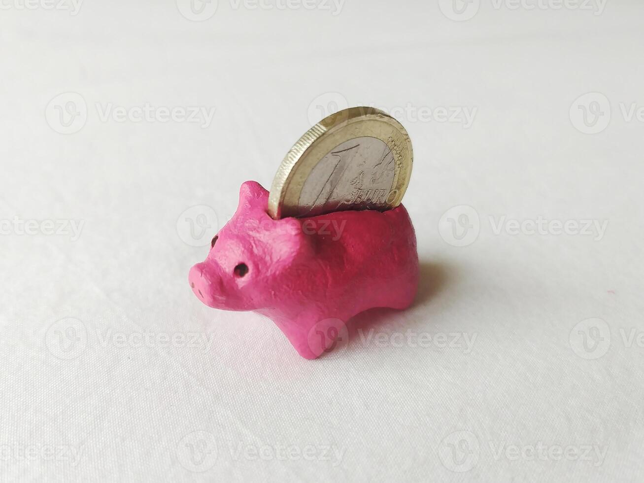 A playful, pink piggy bank with a coin. Concept for savings, finance, and early financial education. Symbol of investment and future security on a clean background. photo