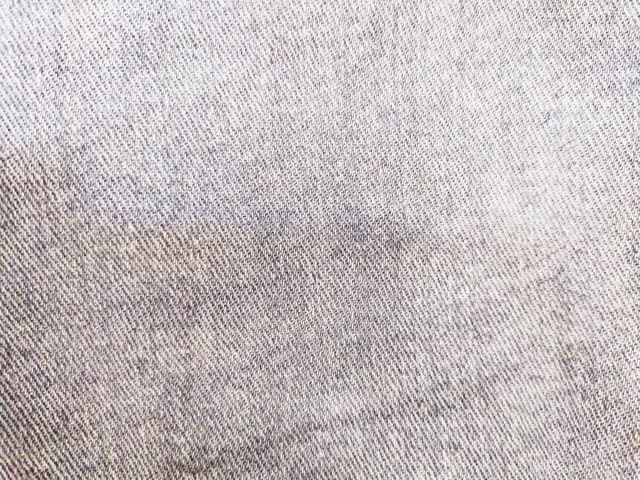 Detailed texture of worn blue denim fabric. Ideal for backgrounds, apparel design, or representing comfort and durability. Versatile and visually appealing. photo