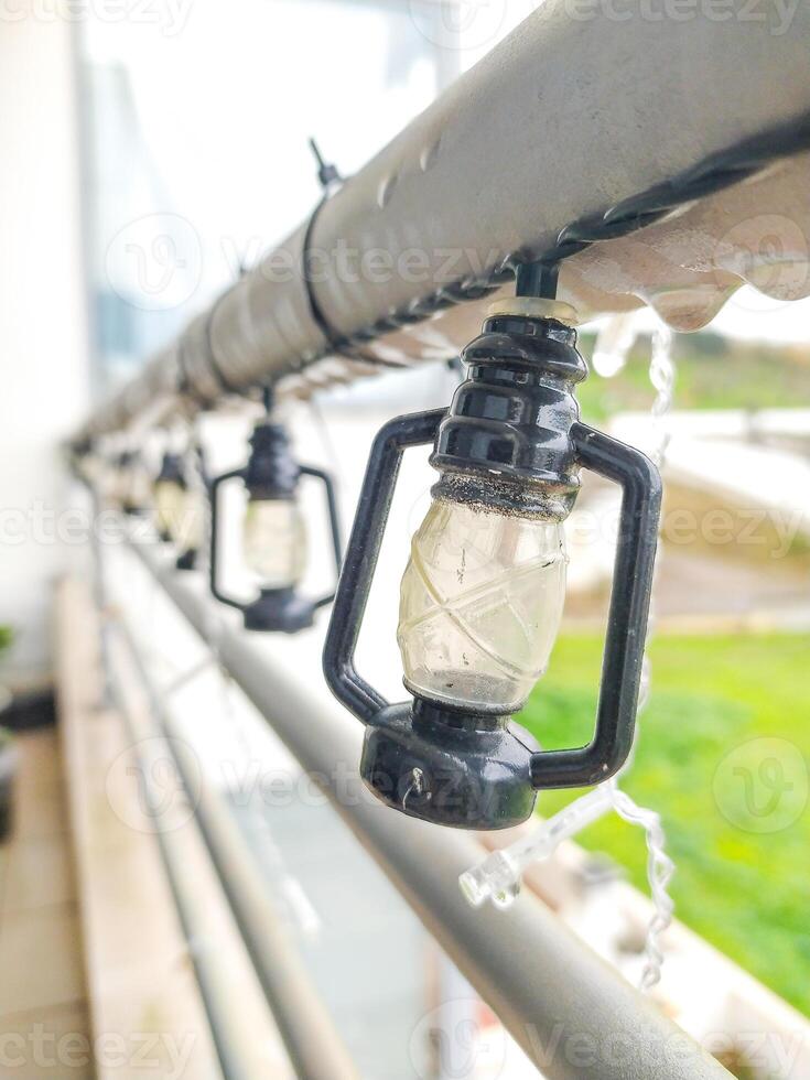 Closeup of charming miniature lantern string lights adorning a balcony railing. Perfect for adding a touch of cozy ambiance to home decor, holiday themes, or outdoor settings. photo