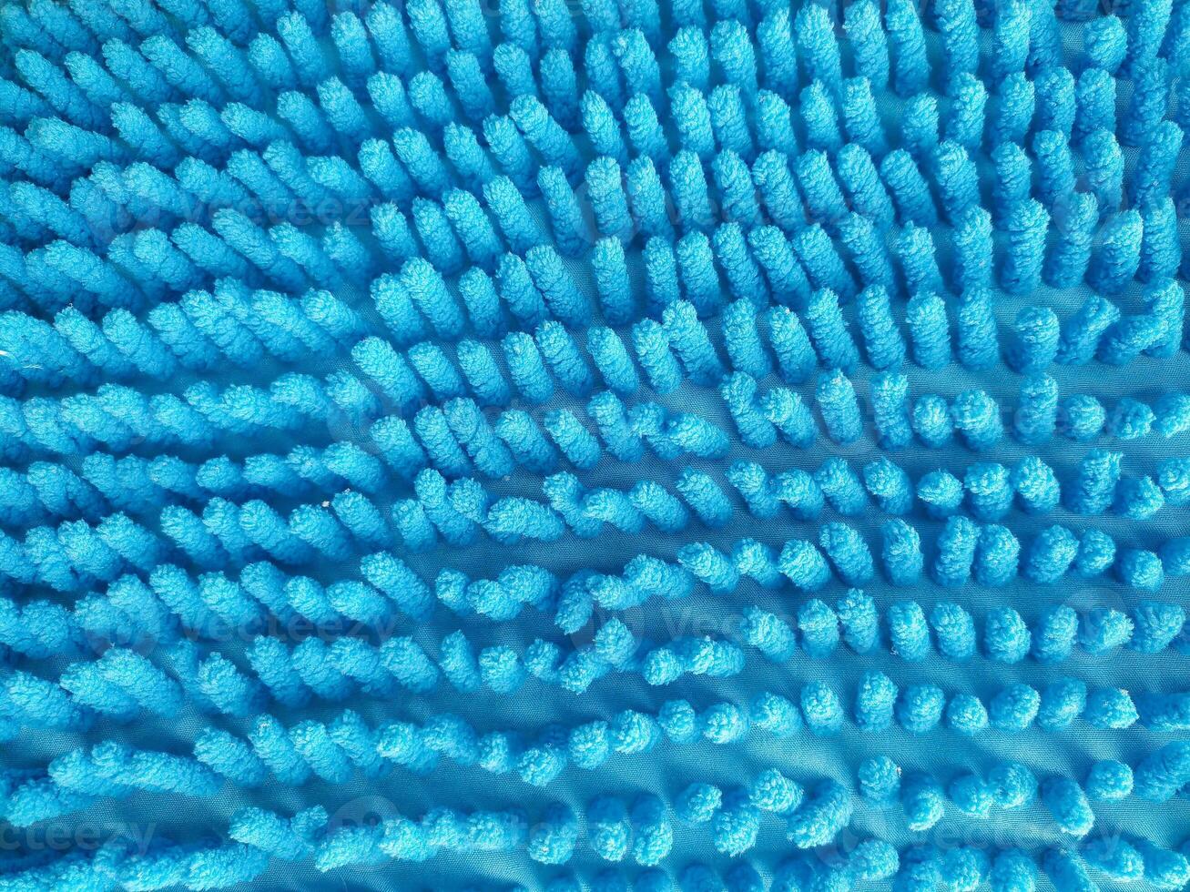Detailed closeup of a textured, fluffy blue surface. Abstract and inviting, suggesting cleanliness, softness, and comfort. Ideal for backgrounds or design elements. photo