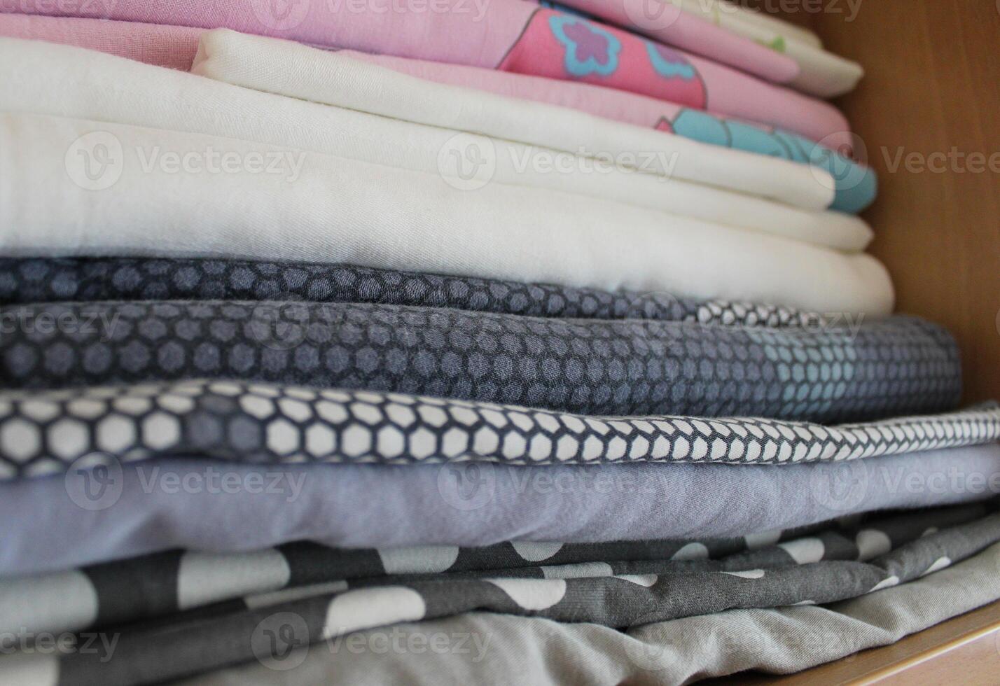 Children Wardrobe Shelf With Stacked Washed Bedclothes Closeup Angle View photo