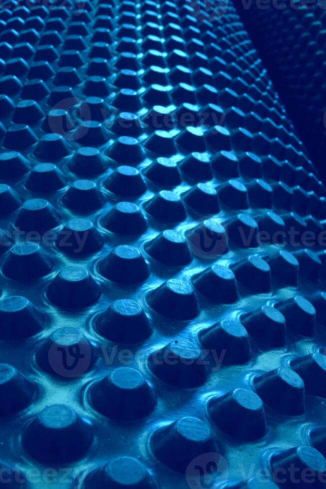 Rows Of Circle Extruded Parts On Cylindrical Structure. Abstract 3D Background With Blue Elements On Rolled Surface photo