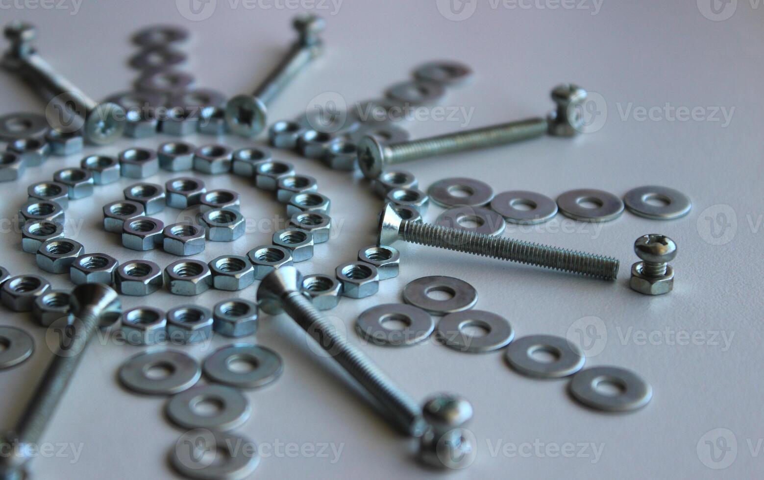 Nuts, Washers And Bolts Arranged In Star Pattern On White Surface Angle View photo