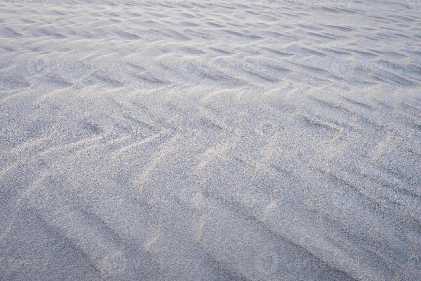 Smooth sand ripples creating a natural abstract texture, perfect as a serene, minimalistic background for creative designs photo
