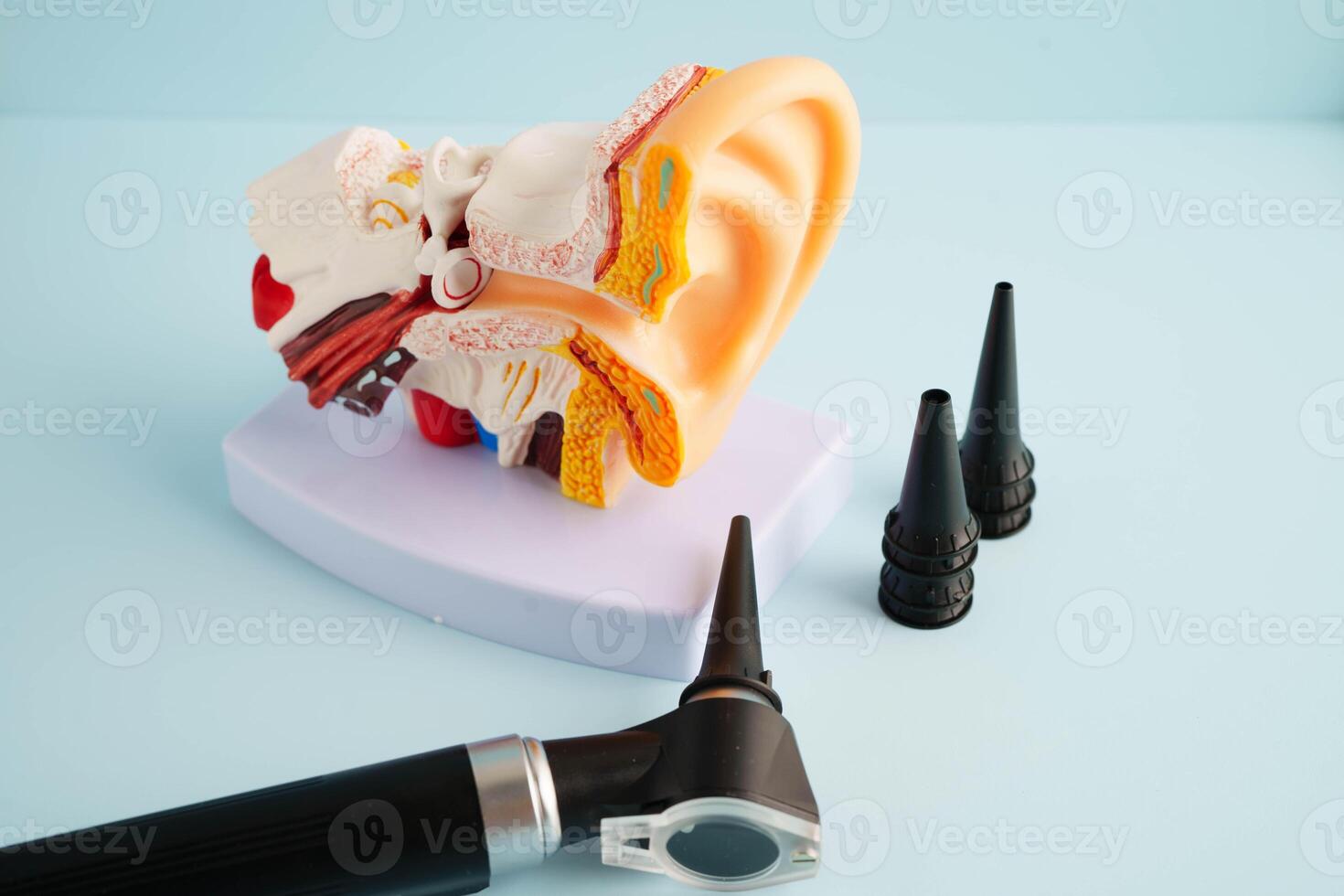 Otoscope with ear model for otolaryngologist or ENT physician doctor examining senior patient ear, hearing loss p photo