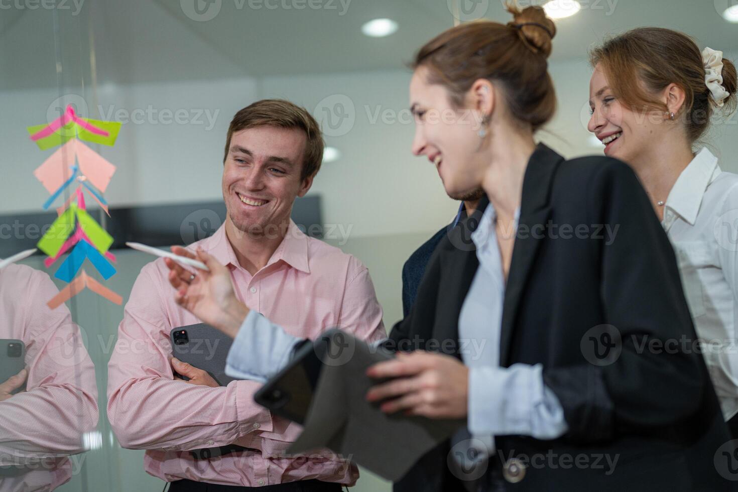 Team members brainstorming ideas during a collaborative session in a modern office workspace in the afternoon photo