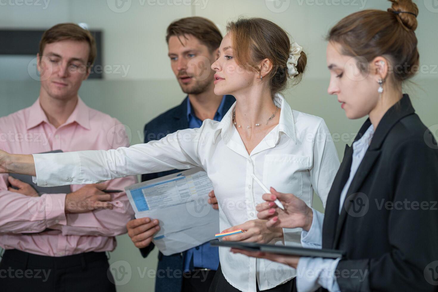 Group of professionals engaged in a discussion during a meeting in a modern office setting photo
