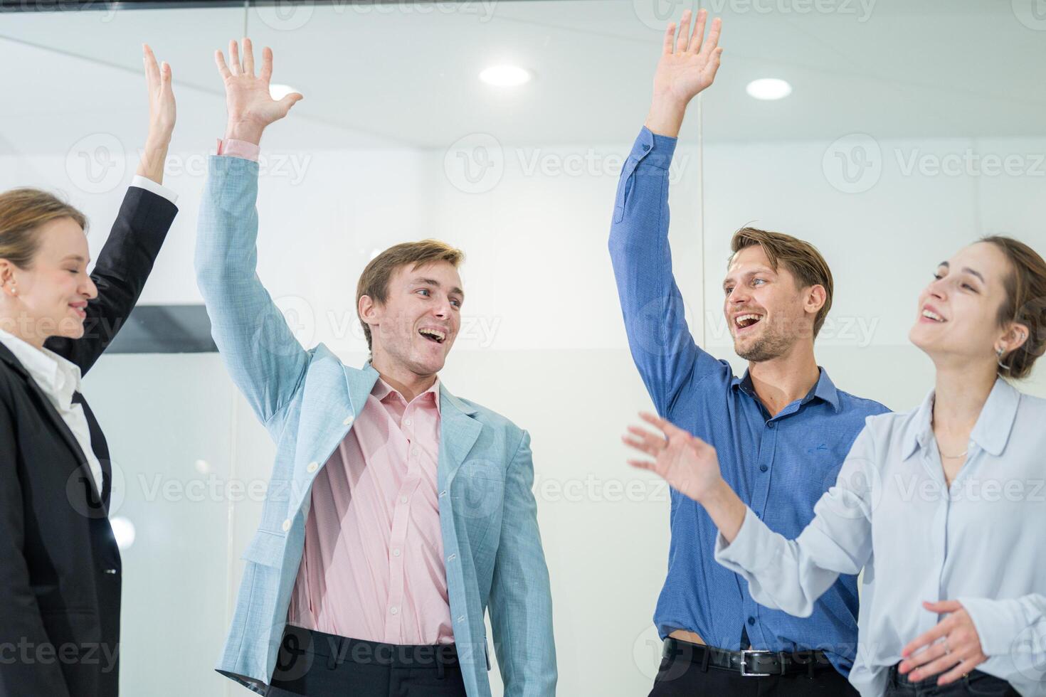 Group of young professionals celebrating success in modern office environment during team meeting photo
