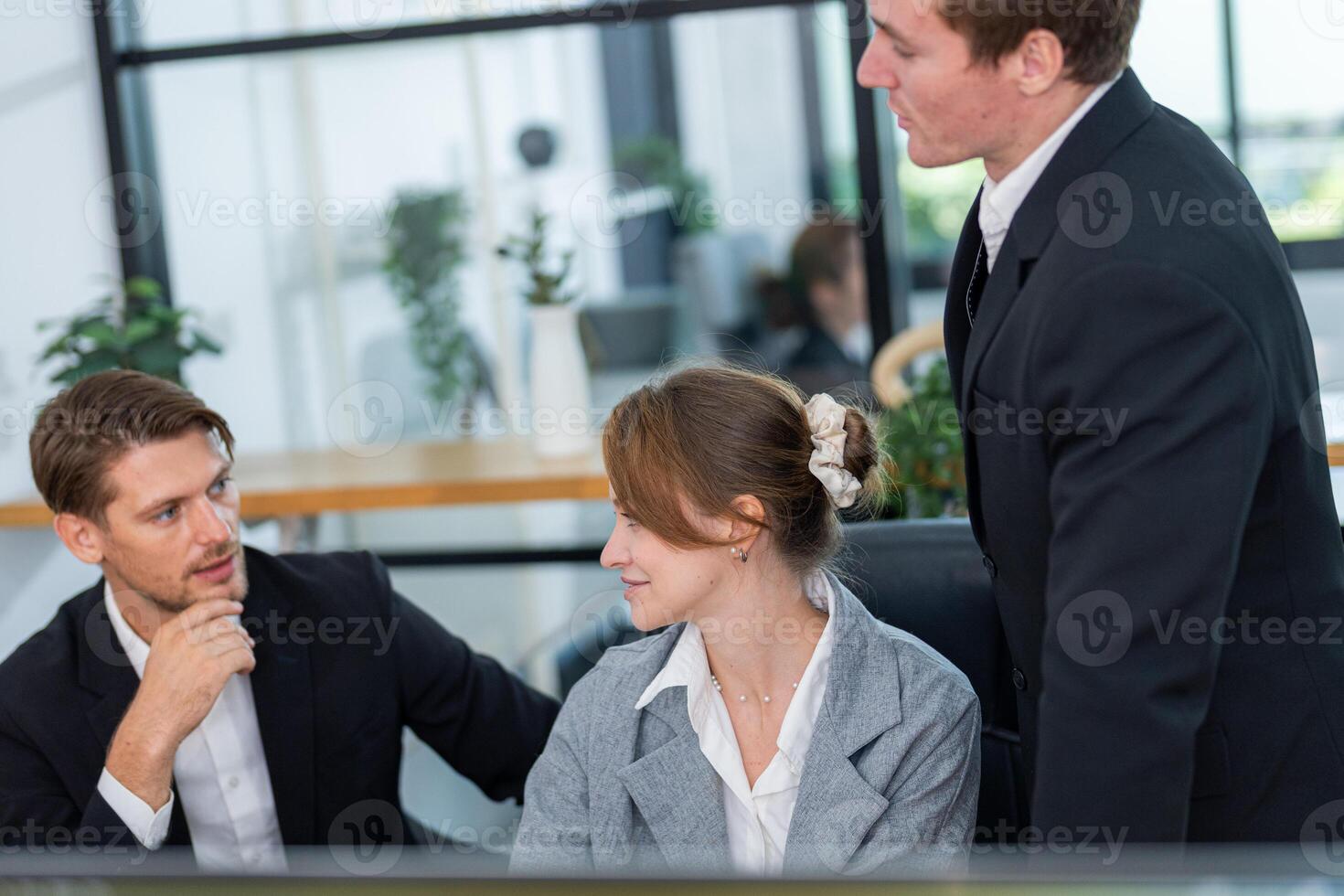 Business professionals engage in a discussion at a modern office workspace in broad daylight photo