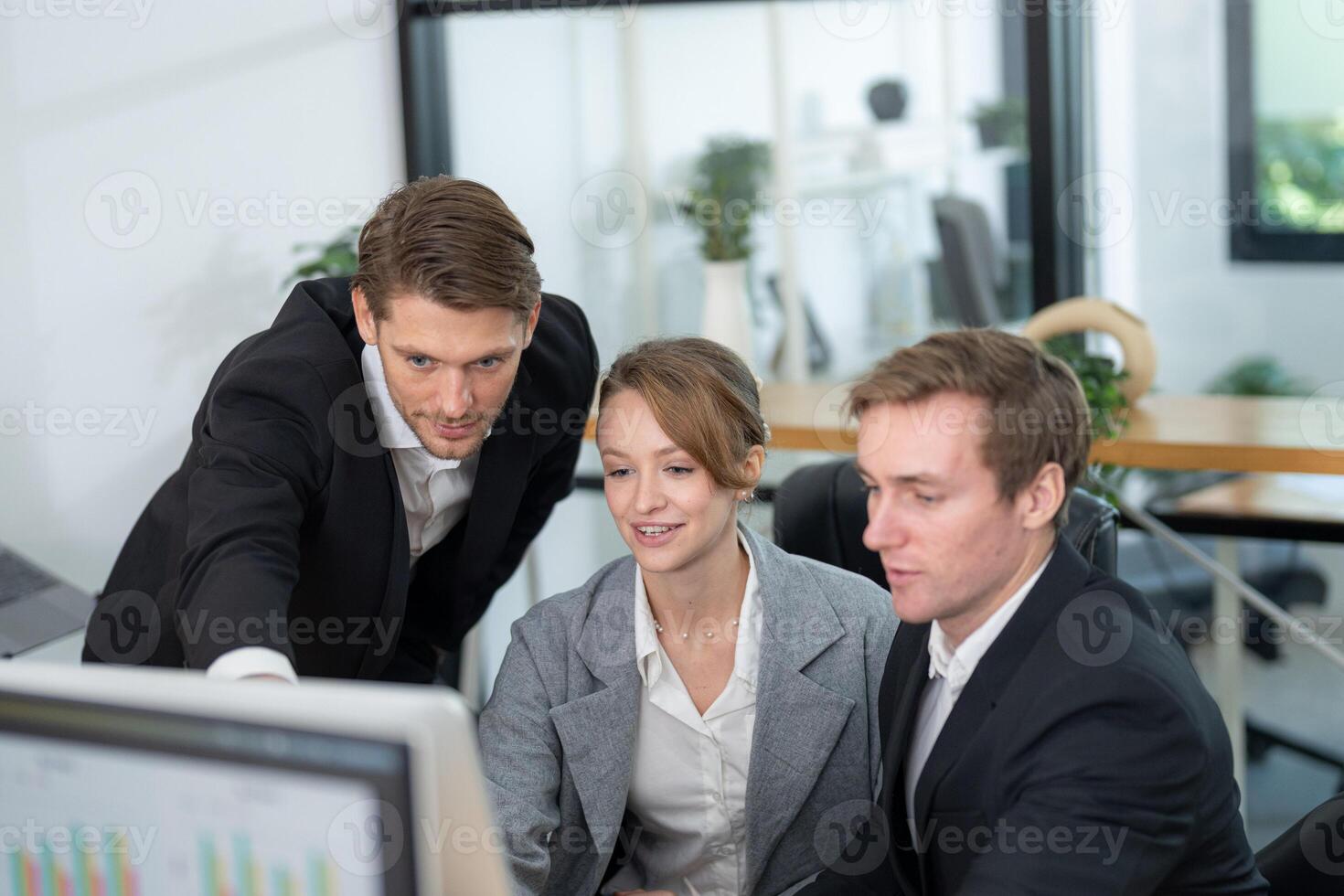 Team collaboration at a modern office as colleagues discuss data on a computer screen photo