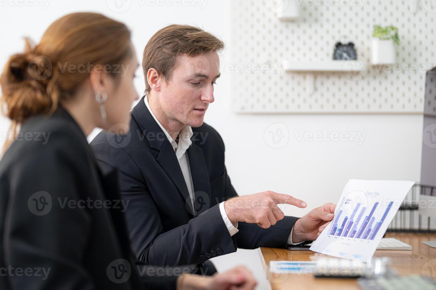 Business professionals discussing a financial report in a modern office setting during the afternoon photo