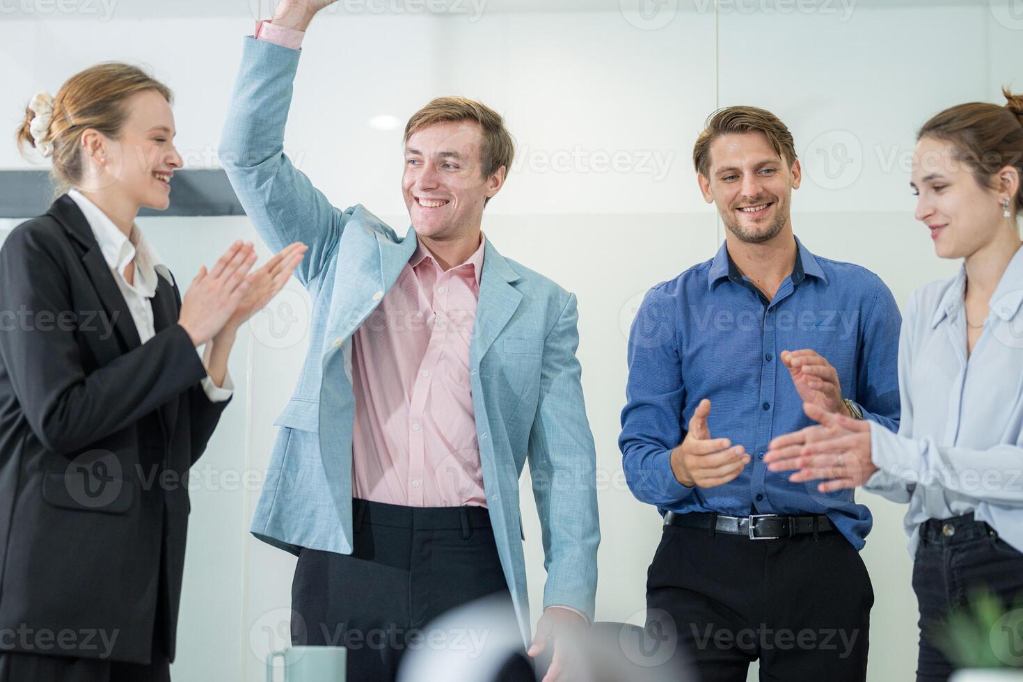 Team celebrates achievement in modern office setting with enthusiastic gestures and smiles around midday photo