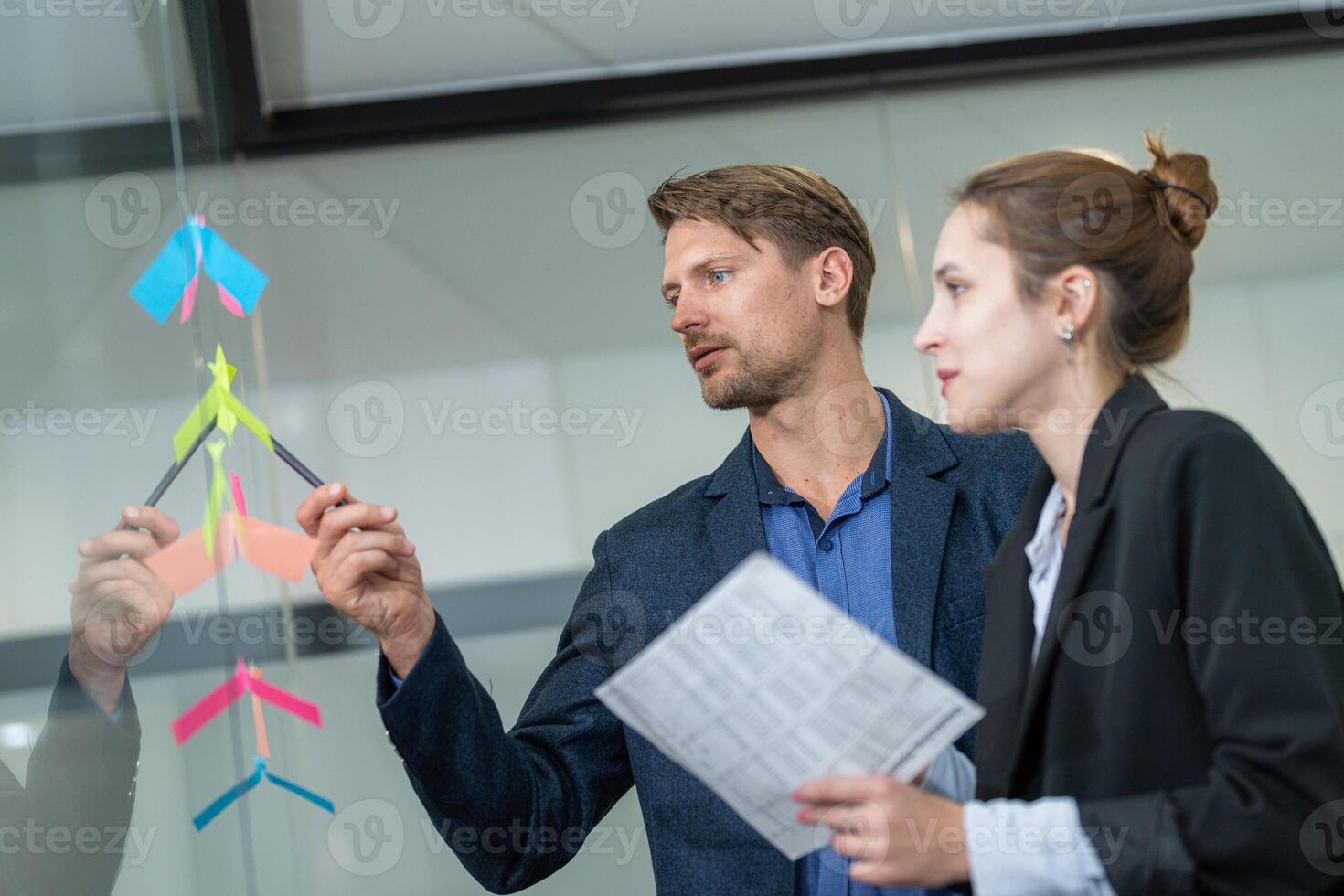 Team members collaborate on project planning using colorful sticky notes in a modern office setting photo