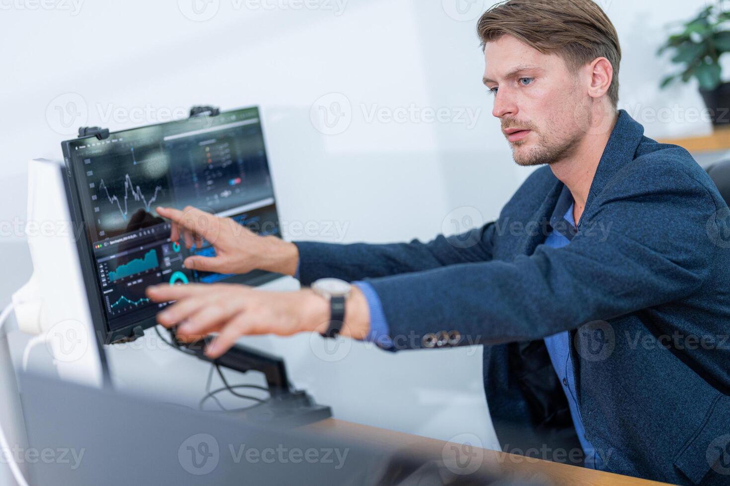 Young professional engaged in data analysis at a modern office during the day, showcasing concentration and expertise in technology usage photo