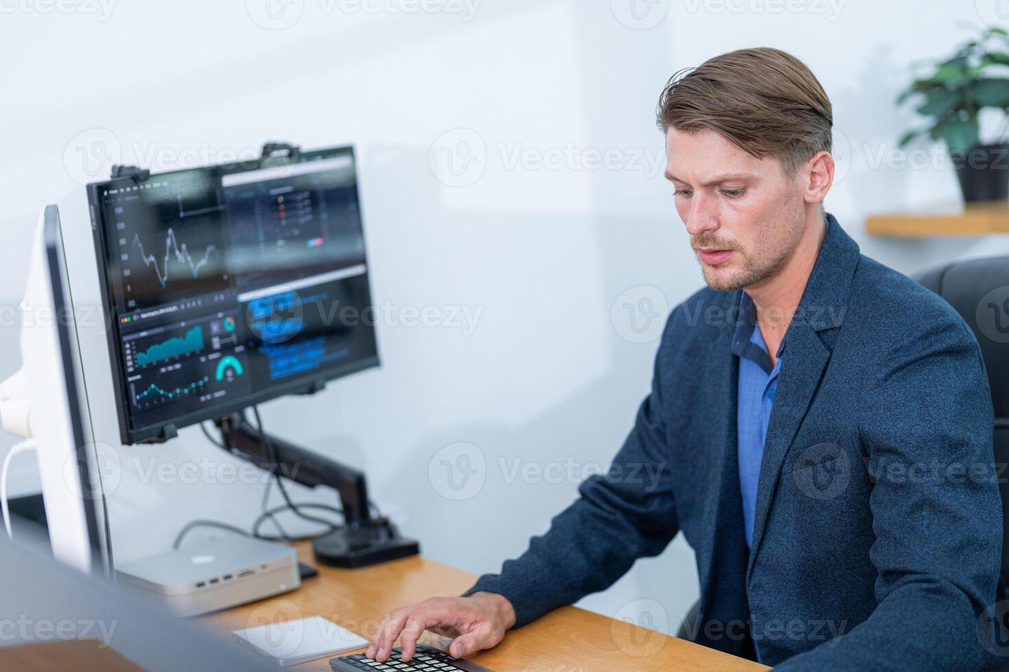 Professional man analyzing data on computer in a modern office setting during daytime photo