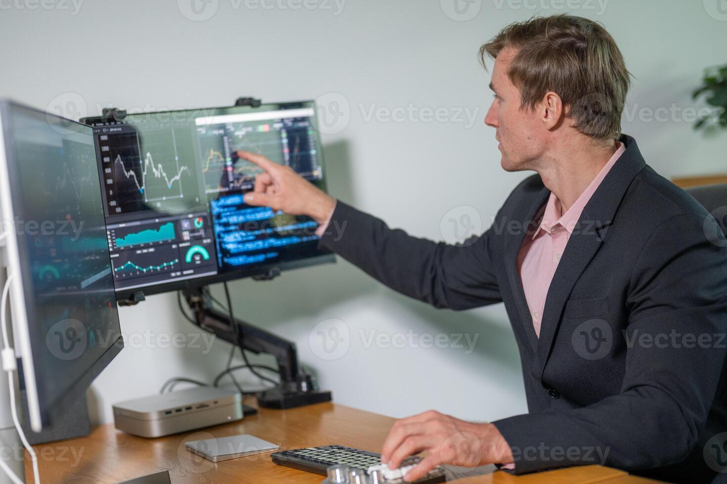 Financial analyst engages in market analysis using multiple monitors in a modern office setting photo