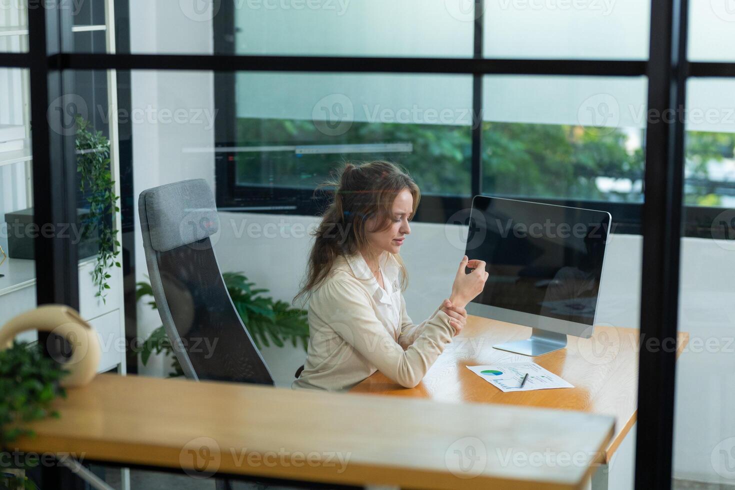 Young professional analyzing data on computer in modern office environment during daytime hours photo