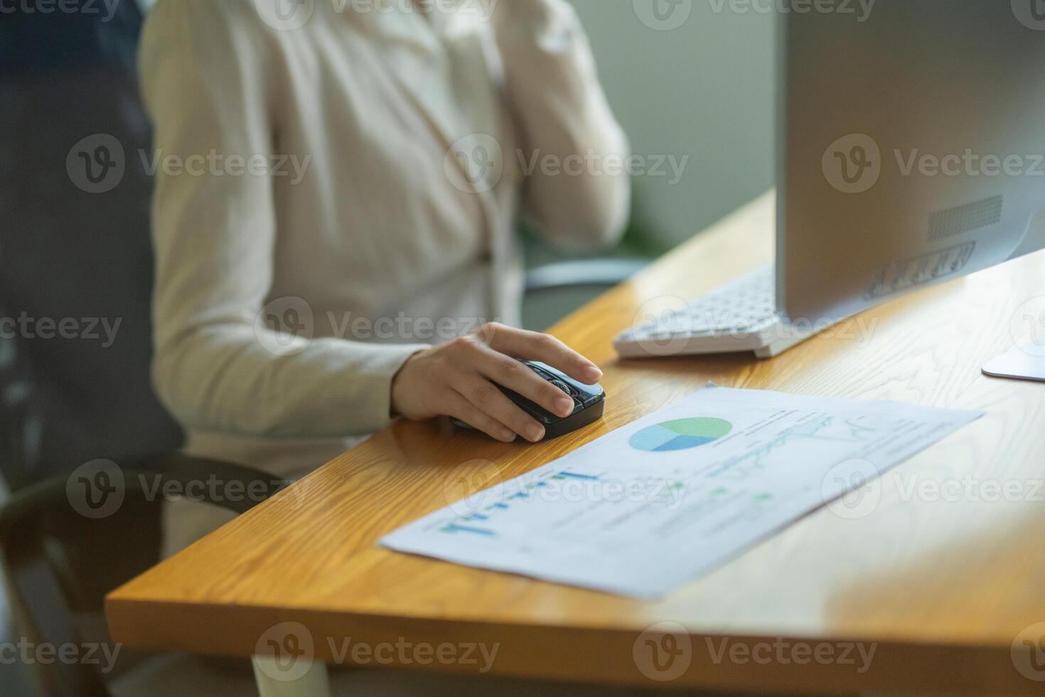 Office worker managing tasks at a desk with computer and documents in bright workspace during afternoon hours photo