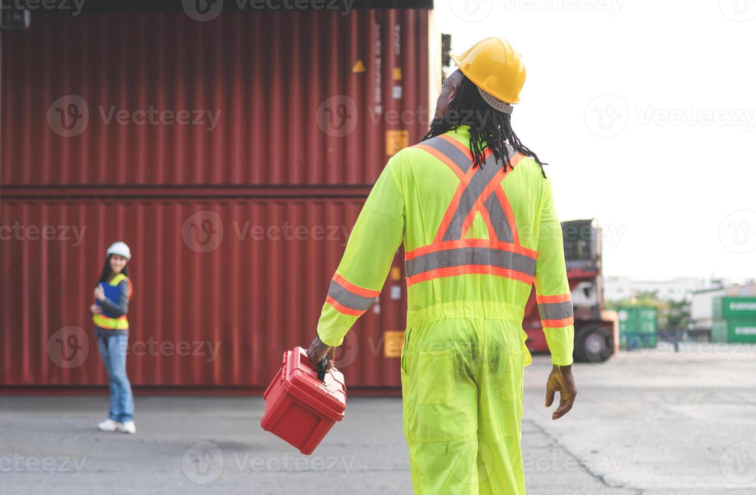 Engineer and foreman dock worker inspecting containers box at cargo, Diverse team of workers collaborating at shipping container cargo photo
