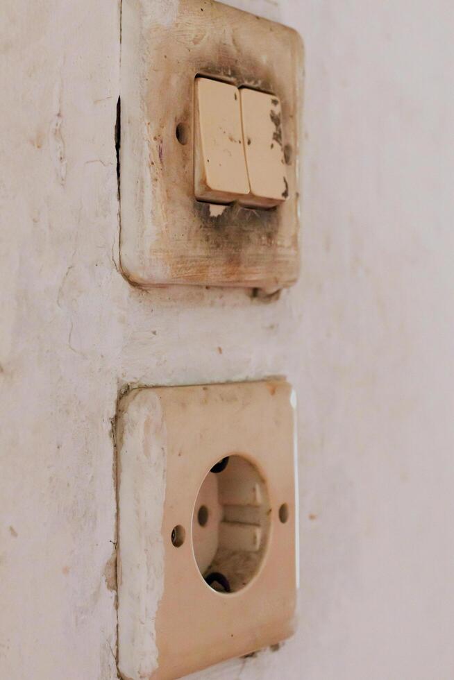 Close up dirty wall electrical switch socket showing wear and decay detail photo