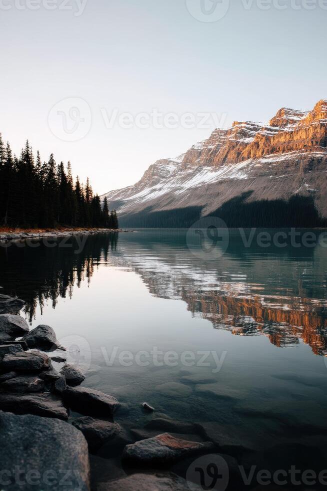 Mountain lake reflects sunrise over tranquil waters photo