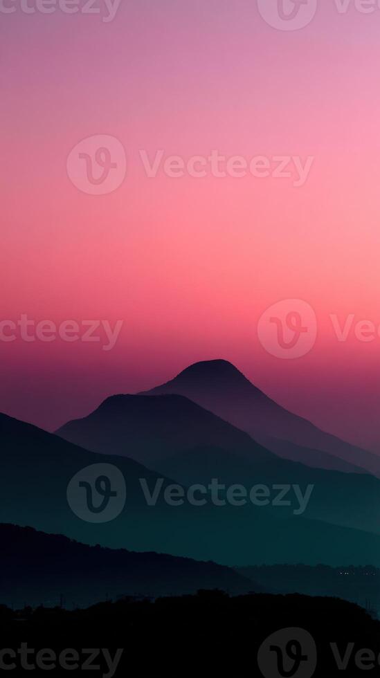 Mountain silhouettes against a pink sunset sky photo