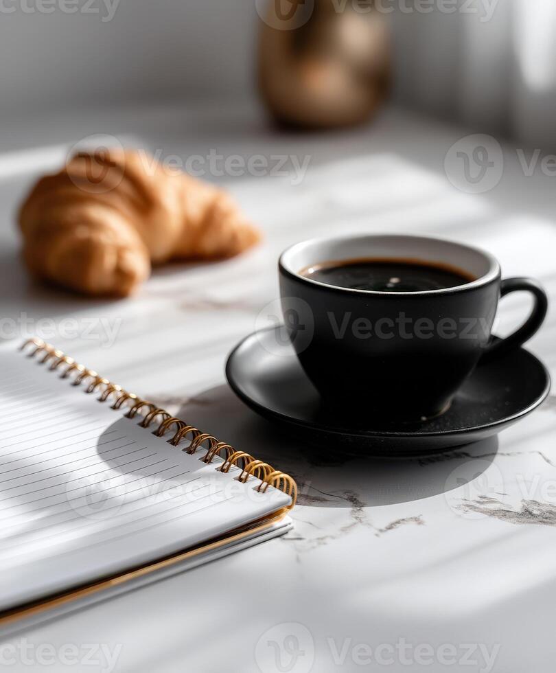 Morning coffee and croissant on a desk photo