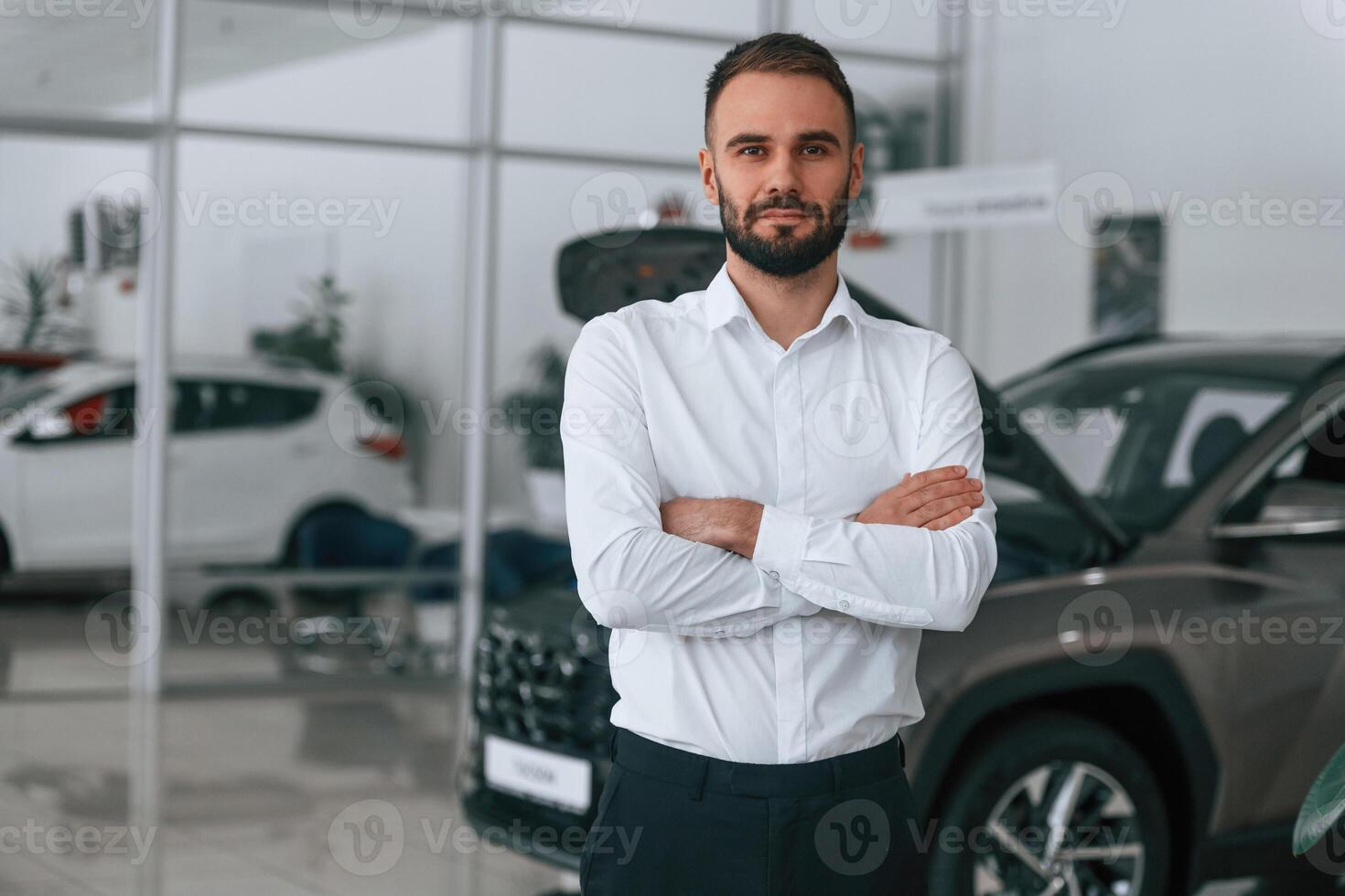 Portrait, of ,beautiful man. Worker ,in formal clothes is in the auto salon photo