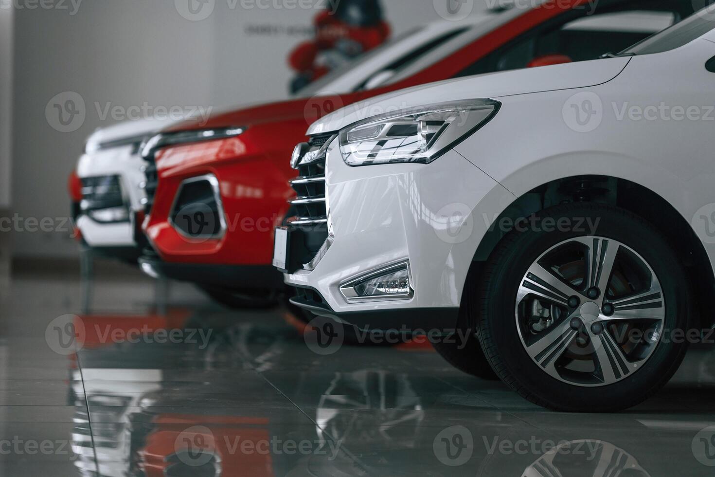 Side view of three cars that are parked ,,in the auto salon photo