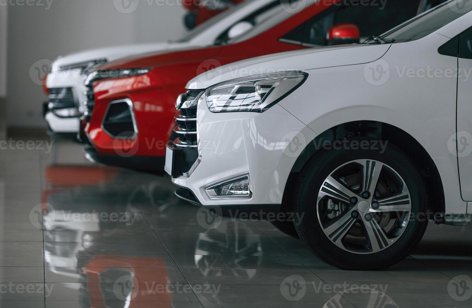 Side view of three cars, that, are parked in the auto salon photo