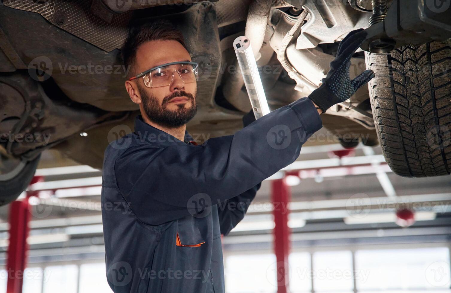 Under the vehicle, fixing.,, Car, repairman is in the garage with automobile photo