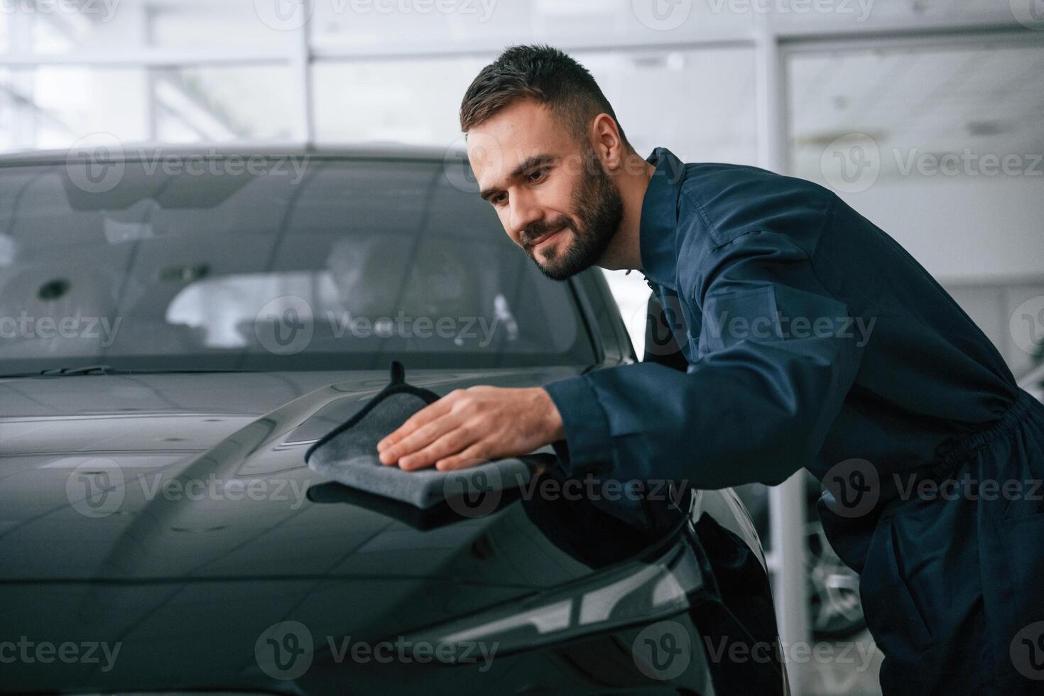 Process of polishing the surface with cloth. Car repairman is in the garage with automobile photo