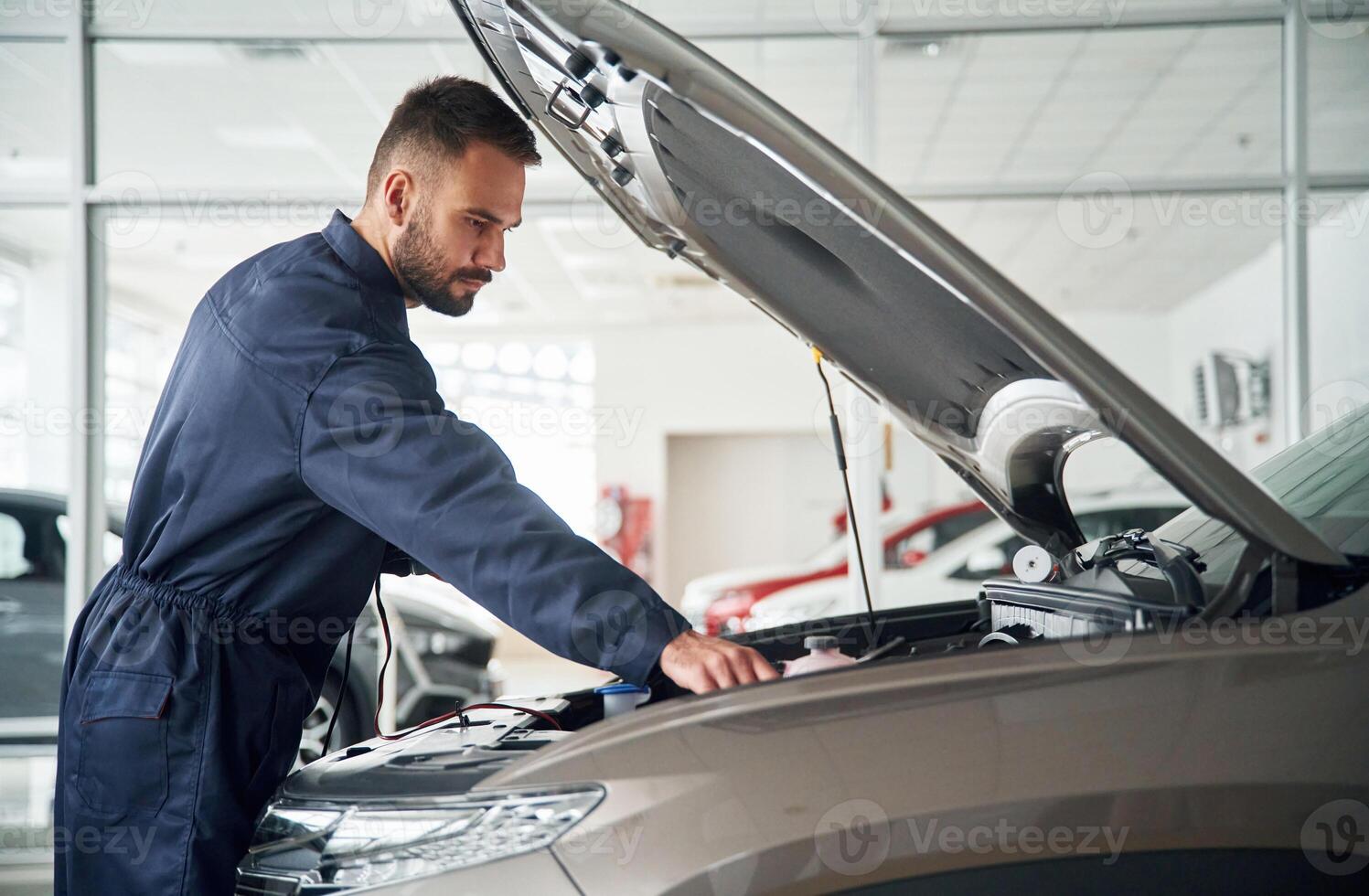 Hood, of vehicle is opened.., Car repairman is in the garage with automobile photo