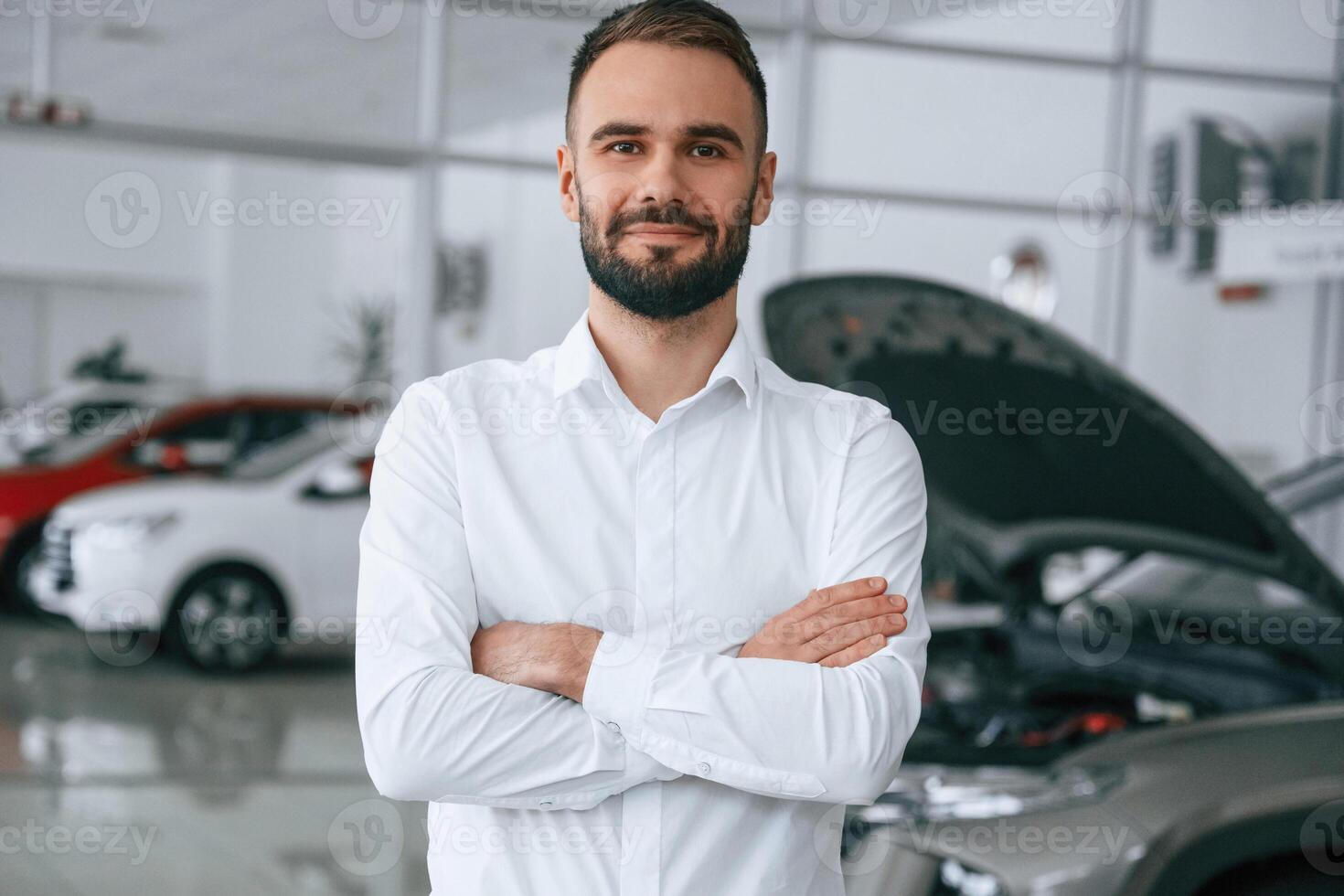 Portrait ,of beautiful man. Worker in formal clothes is in the auto salon photo